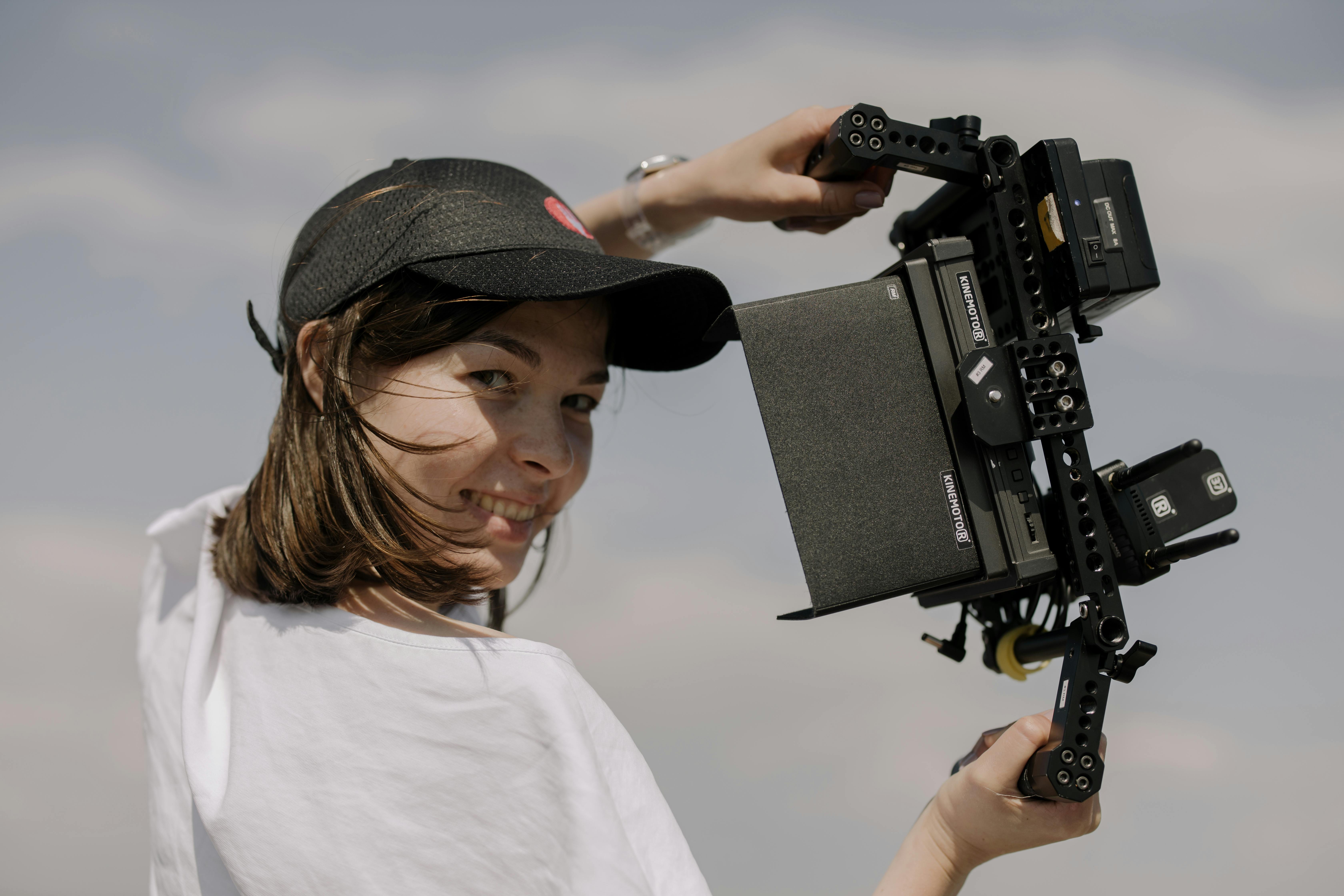 Brunette woman recording video with a professional camera.