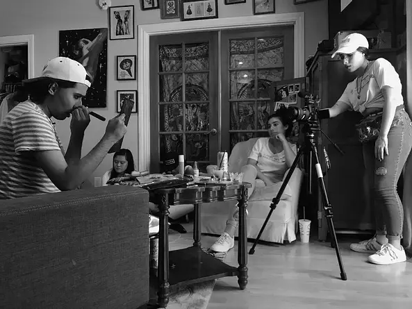 A young woman operates a professional film camera during a Girls' Voices Now workshop